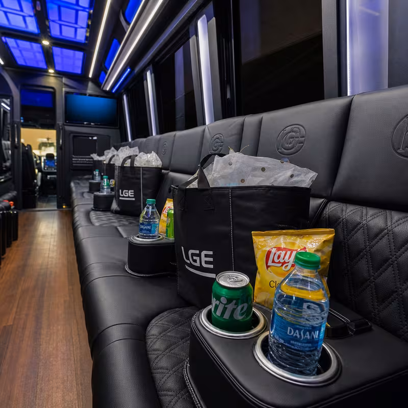 Party bus interior with wraparound leather seating and LED lighting in Glendale